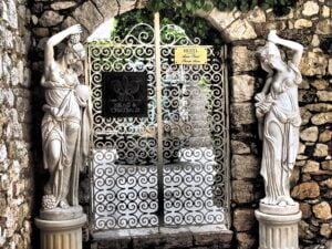 Accès privé du célèbre hôtel-restaurant "la Chèvre d'or".Il s'agit d'une grille très travaillée encadrée de deux statues de type classique inspirées de la grèce antique avec des femmes aux seins nus